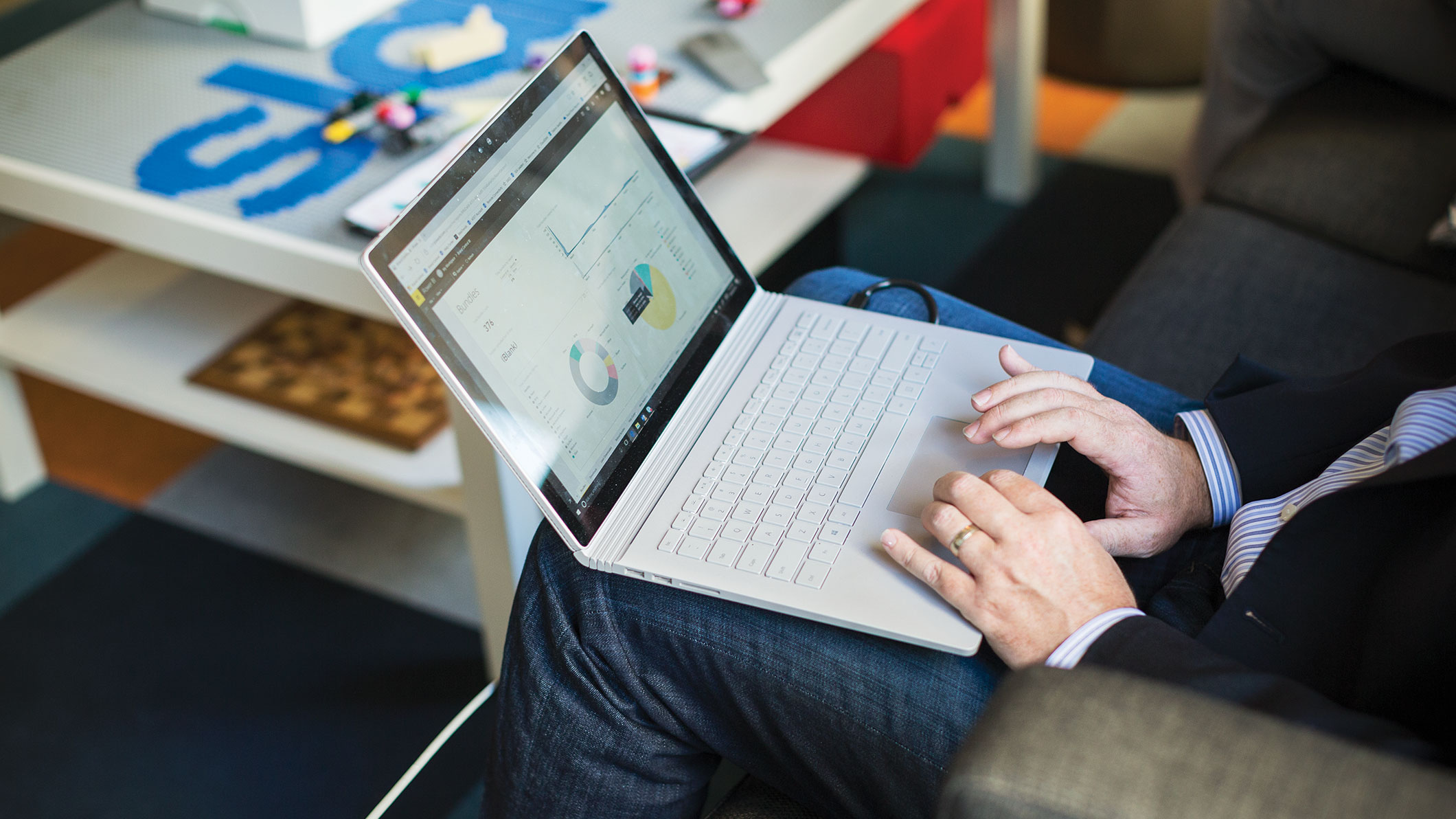 A person uses a laptop perched on their lap.