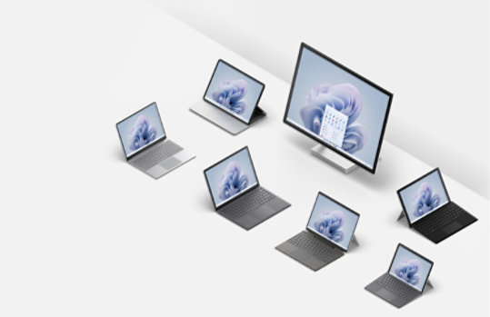 A collection of Surface laptops, 2 in 1s and desktop computers featured in various angles and positions.