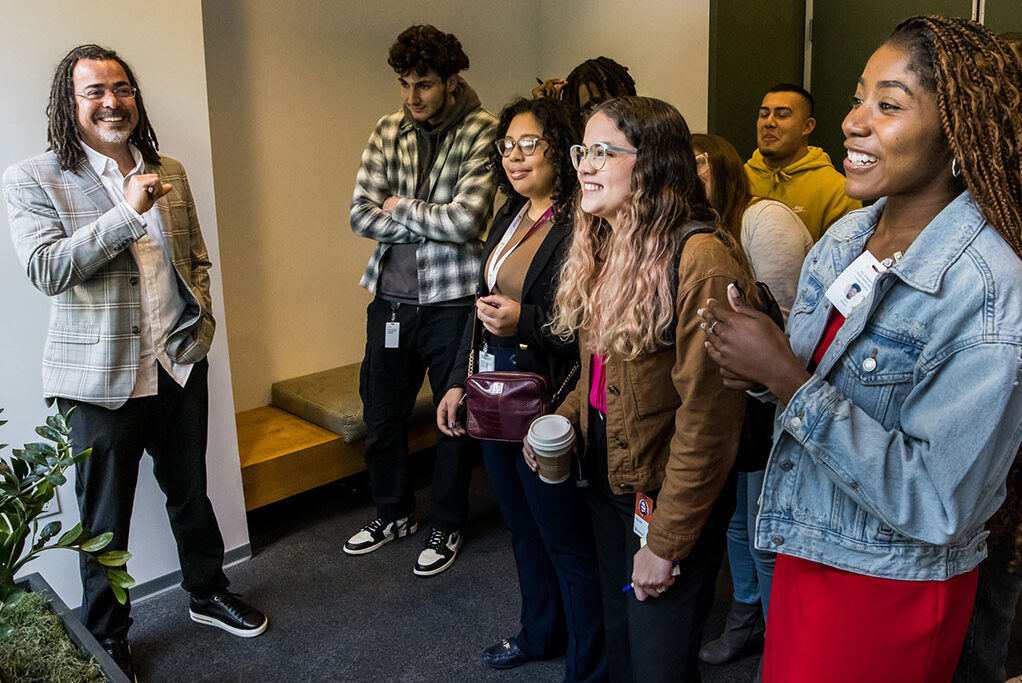 Man smiling as he stands with a group of students