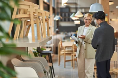 A retail employee and customer looking at furniture and a tablet in a showroom