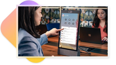 A person using a touchscreen Teams display at a flexible workspace to dial a number and make a call.
