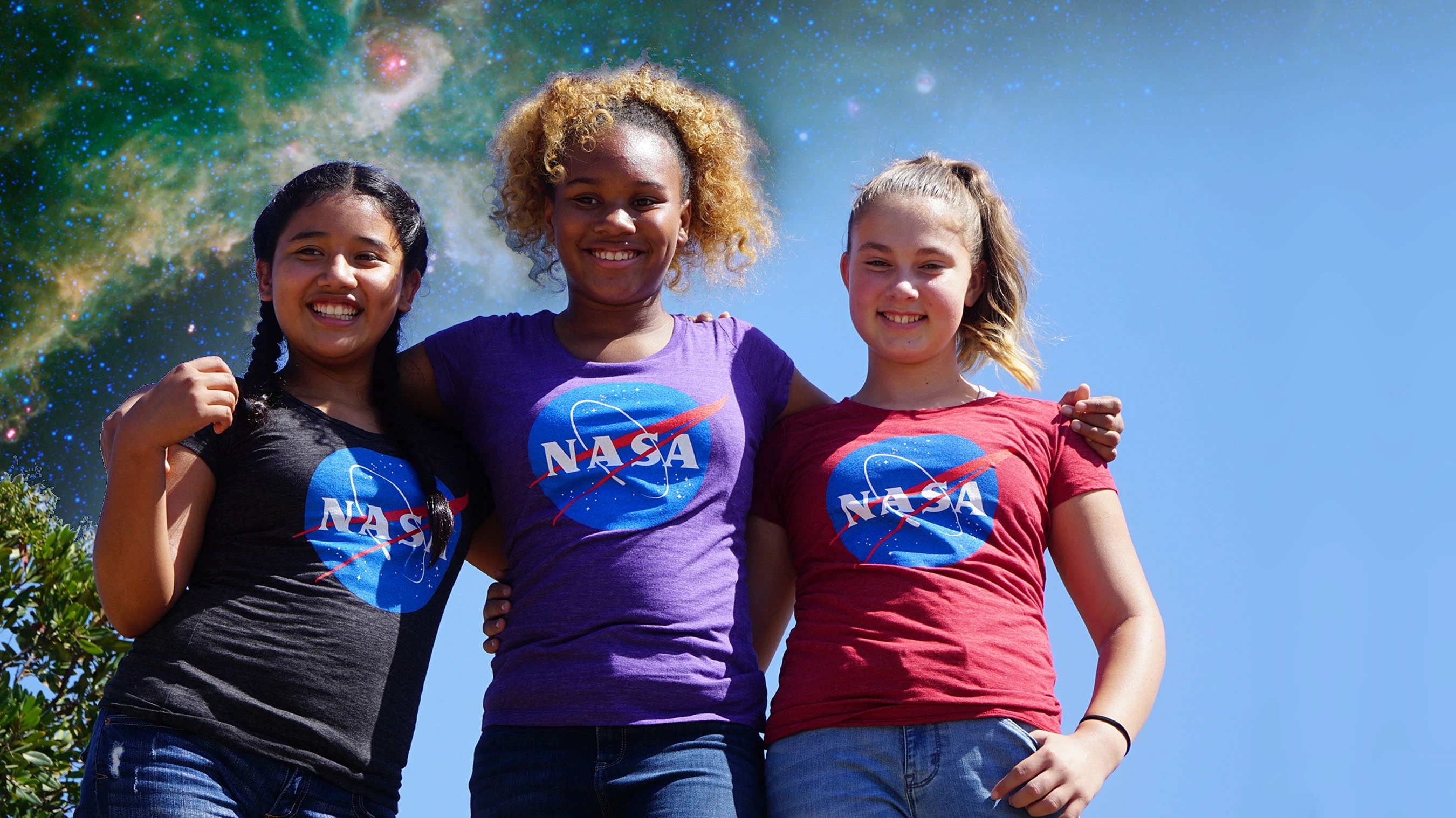 3 girls wearing NASA shirts smile for the camera