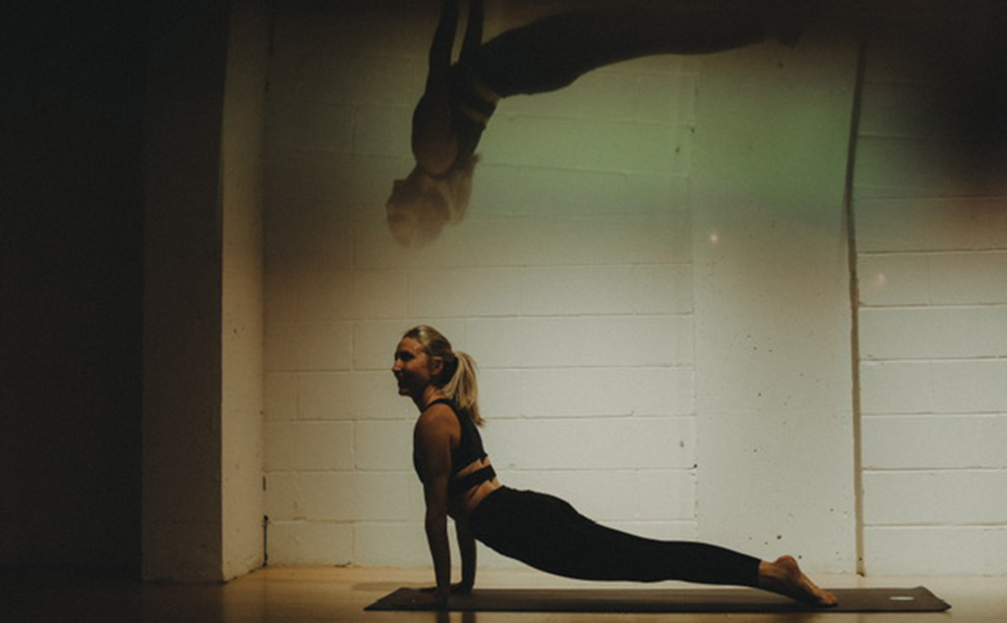 Britton Schey doing yoga with her reflection on top of her