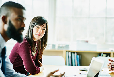 A group of people sitting around a table in an office.
