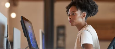 A woman is sitting at a desk in front of a computer.