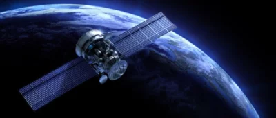 A satellite with extended solar panels orbits earth, set against the dark backdrop of space.