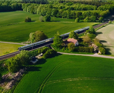 A train going through a green field.
