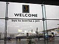Powitanie w dwóch językach na lotnisku Jersey; na górze widać powitanie w języku angielskim, poniżej powitanie w regionalnym języku Jèrriais